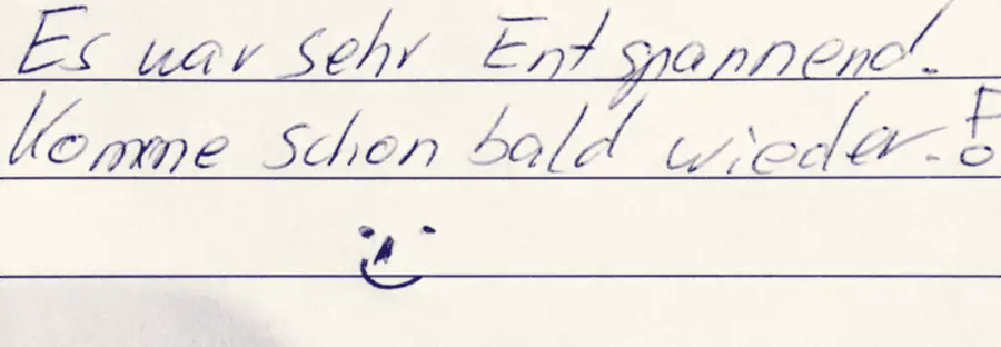 Aufgeschlagene Gästebuchseite mit einem handschriftlichen Eintrag in blauer Tinte