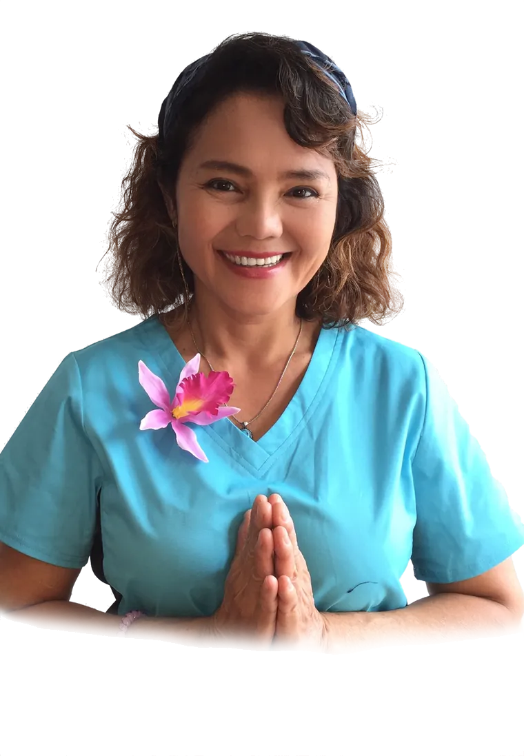 Ling, Inhaberin von Thai Massage Hunsrück, in türkiser Arbeitskleidung mit einer Orchidee am Kragen und zum Wai gefalteten Händen